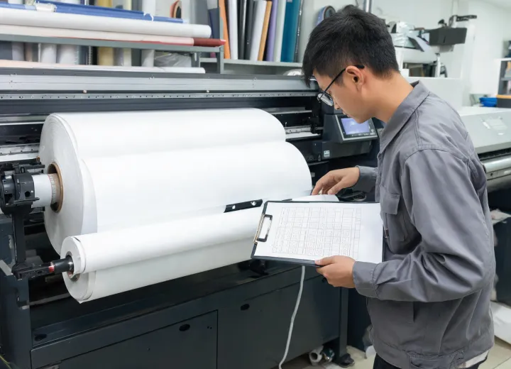 Operator checking media tracking at a printer